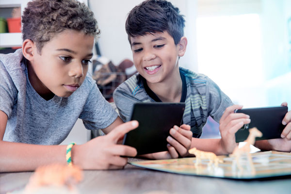 Two boys playing handheld gaming devices